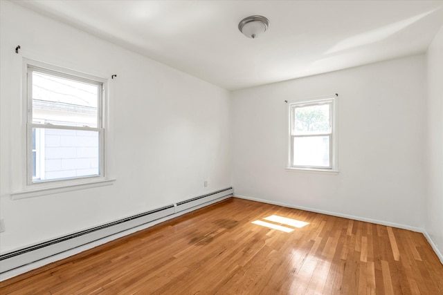 1159 129th St, College Point, NY 11356 - empty room featuring a baseboard heating unit and light wood-type flooring