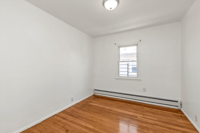 1159 129th St, College Point, NY 11356 - spare room featuring baseboard heating and light wood-type flooring