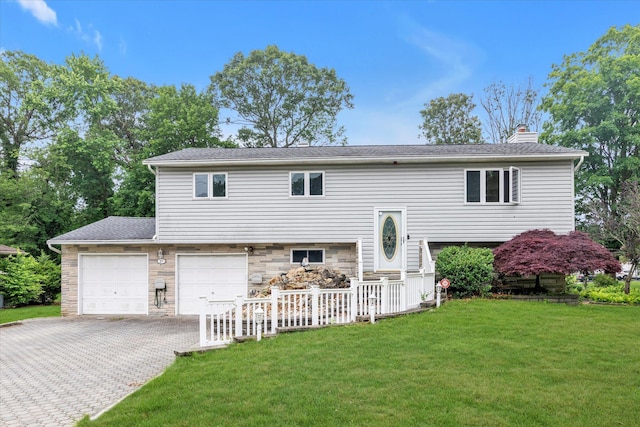 27 Heron Ln, Commack, NY 11725 - back of property featuring driveway, a lawn, a chimney, stone siding, and an attached garage