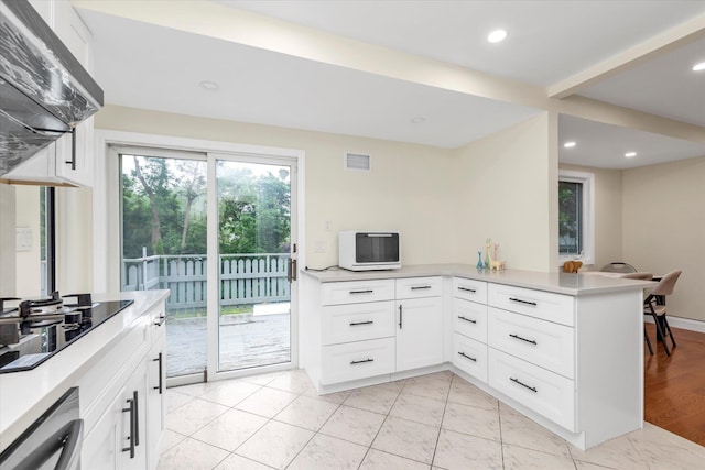 27 Heron Ln, Commack, NY 11725 - kitchen featuring extractor fan, black electric cooktop, light countertops, white cabinets, and recessed lighting