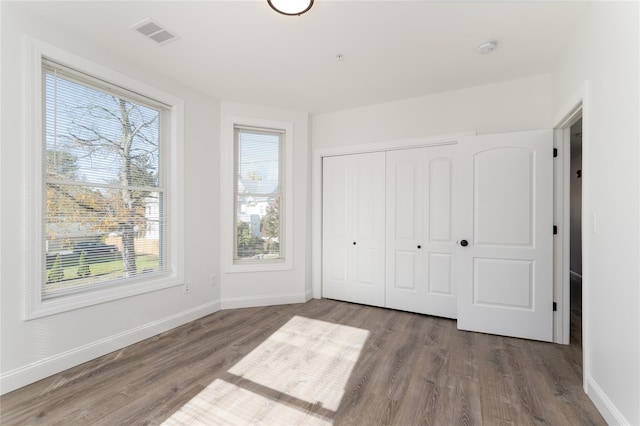 22 Forbus St, Poughkeepsie, NY 12601 - unfurnished bedroom with multiple windows, wood finished floors, and a closet