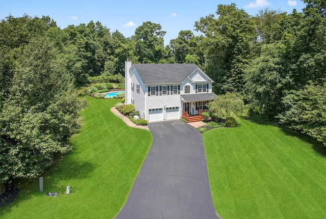 85 Decker Dr, Walden, NY 12586 - colonial home with asphalt driveway, a front lawn, an attached garage, a chimney, and a porch