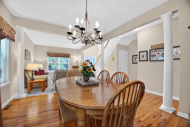 85 Decker Dr, Walden, NY 12586 - dining room with light wood-type flooring, a chandelier, ornate columns, and stairs