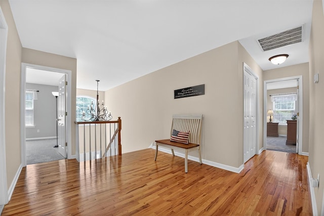 85 Decker Dr, Walden, NY 12586 - hall with wood finished floors, a chandelier, an upstairs landing, and plenty of natural light