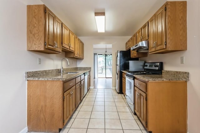 175 Horseshoe Cir, Ossining, NY 10562 - kitchen with stainless steel appliances, under cabinet range hood, brown cabinetry, light tile patterned flooring, and stone counters