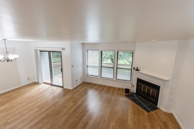 175 Horseshoe Cir, Ossining, NY 10562 - unfurnished living room with a chandelier, wood finished floors, and a glass covered fireplace