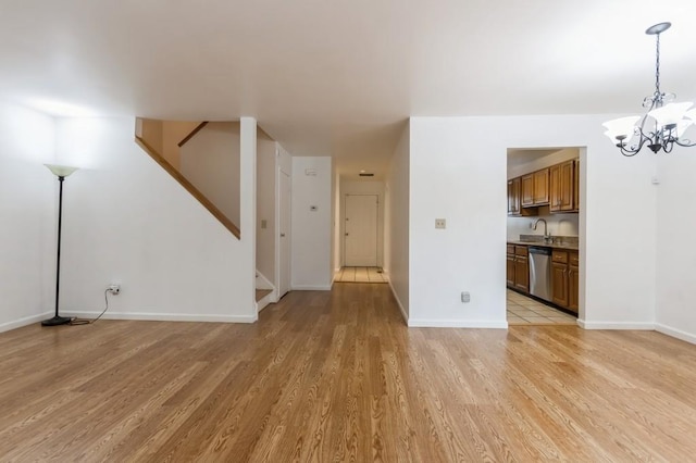 175 Horseshoe Cir, Ossining, NY 10562 - unfurnished living room featuring stairway, light wood-style floors, and a chandelier