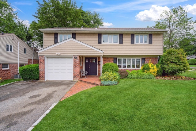 9 Elaine Pl, Plainview, NY 11803 - view of front facade with a garage, brick siding, asphalt driveway, and a front lawn