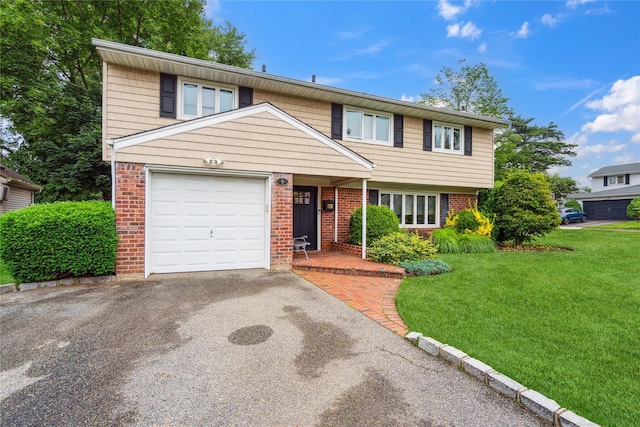 9 Elaine Pl, Plainview, NY 11803 - view of front of home with brick siding, a front yard, asphalt driveway, and an attached garage