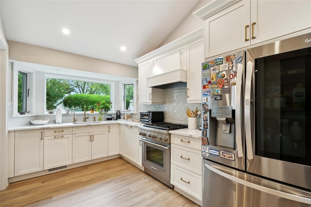 9 Elaine Pl, Plainview, NY 11803 - kitchen with stainless steel appliances, premium range hood, decorative backsplash, light countertops, and white cabinets