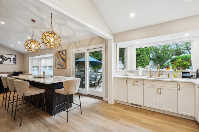 9 Elaine Pl, Plainview, NY 11803 - kitchen featuring lofted ceiling, light wood-style floors, plenty of natural light, a breakfast bar, and recessed lighting