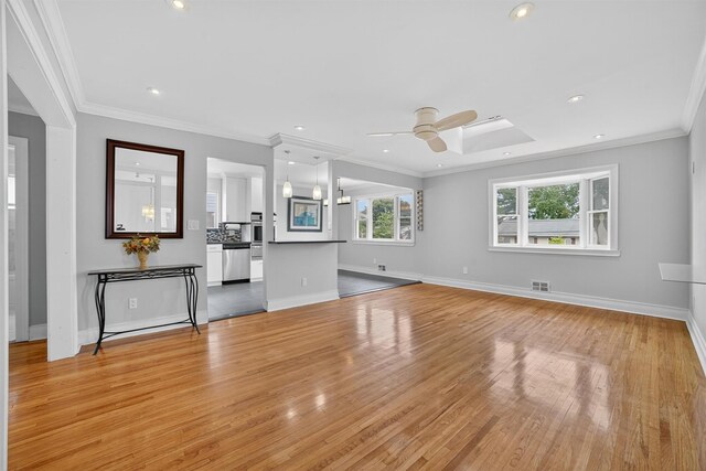 7 Fuller Rd, Ossining, NY 10562 - unfurnished living room featuring a ceiling fan, light wood-style flooring, a skylight, ornamental molding, and recessed lighting