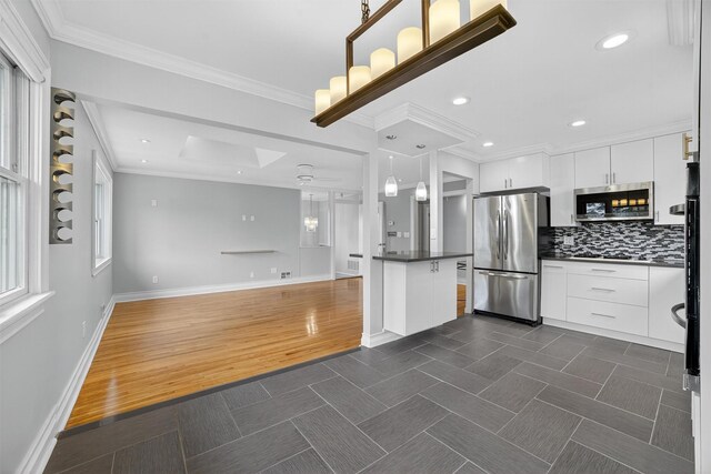 7 Fuller Rd, Ossining, NY 10562 - kitchen with stainless steel appliances, dark countertops, a skylight, backsplash, and white cabinets