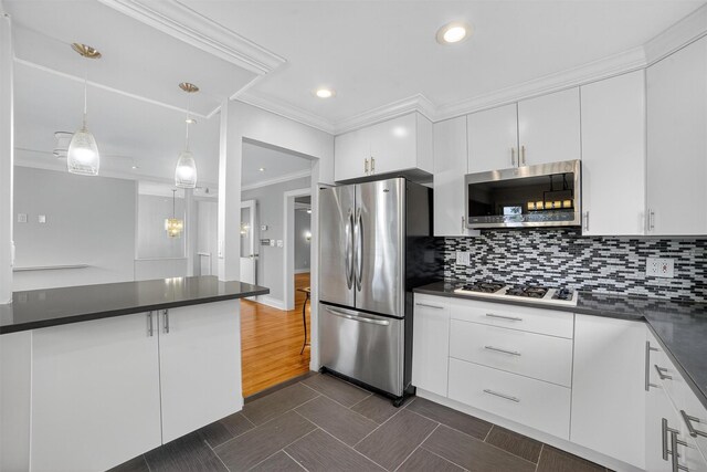 7 Fuller Rd, Ossining, NY 10562 - kitchen featuring appliances with stainless steel finishes, dark countertops, ornamental molding, white cabinetry, and recessed lighting