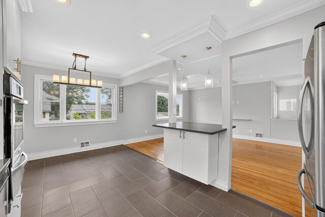 7 Fuller Rd, Ossining, NY 10562 - kitchen with appliances with stainless steel finishes, white cabinets, dark countertops, decorative light fixtures, and crown molding