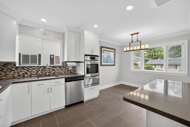 7 Fuller Rd, Ossining, NY 10562 - kitchen featuring stainless steel appliances, a warming drawer, dark countertops, decorative backsplash, and crown molding