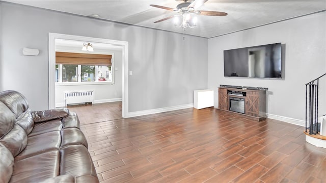 17111 Bagley Ave, Flushing, NY 11358 - living room featuring radiator heating unit, a ceiling fan, wood finished floors, and a glass covered fireplace