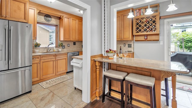 17111 Bagley Ave, Flushing, NY 11358 - kitchen featuring appliances with stainless steel finishes, decorative backsplash, healthy amount of natural light, and a breakfast bar area