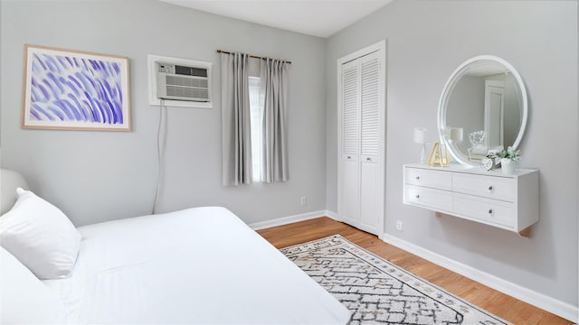 17111 Bagley Ave, Flushing, NY 11358 - bedroom with light wood-style flooring, a closet, and a wall unit AC