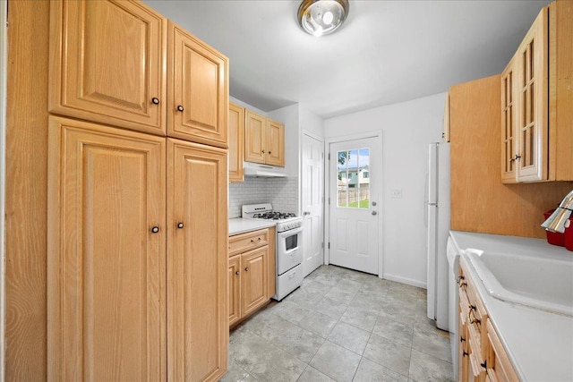 65 Schmeelk Pl, Copiague, NY 11726 - kitchen with white appliances, under cabinet range hood, light countertops, glass insert cabinets, and backsplash