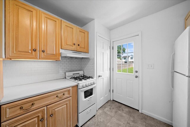 65 Schmeelk Pl, Copiague, NY 11726 - kitchen with white appliances, under cabinet range hood, backsplash, and light countertops