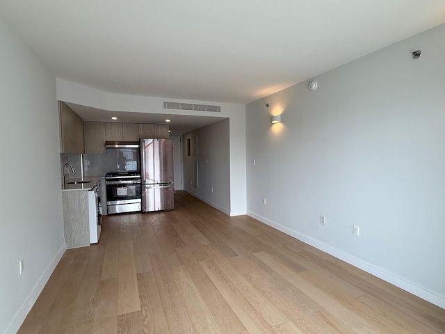 136-80 41st Ave Unit 6G, Flushing, NY 11355 - kitchen with appliances with stainless steel finishes, light wood finished floors, light countertops, modern cabinets, and decorative backsplash