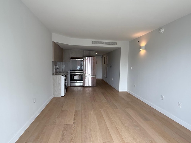 136-80 41st Ave Unit 6G, Flushing, NY 11355 - kitchen featuring stainless steel appliances, light wood finished floors, under cabinet range hood, and light countertops