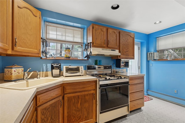 18 Berkeley Ave, Selden, NY 11784 - kitchen with gas range gas stove, under cabinet range hood, baseboard heating, light countertops, and plenty of natural light
