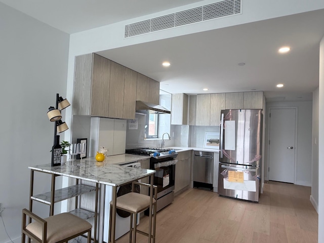 136-80 41st Ave Unit 6H, Flushing, NY 11355 - kitchen featuring stainless steel appliances, a peninsula, light wood-style floors, modern cabinets, and light stone counters