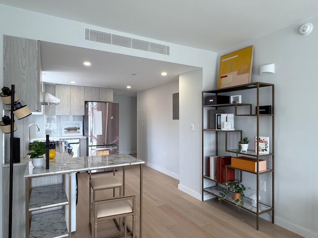 136-80 41st Ave Unit 6H, Flushing, NY 11355 - kitchen featuring freestanding refrigerator, light wood-style floors, a peninsula, recessed lighting, and a kitchen bar