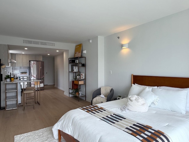 136-80 41st Ave Unit 6H, Flushing, NY 11355 - bedroom featuring freestanding refrigerator, light wood-type flooring, and recessed lighting