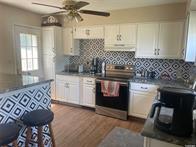 50 Cliff Ln, Levittown, NY 11756 - kitchen featuring stainless steel range with electric cooktop, a ceiling fan, white cabinetry, decorative backsplash, and dark wood-style floors