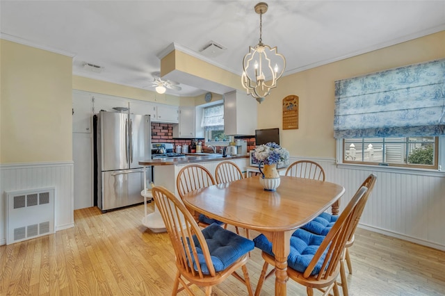 15 Peony Ln, Commack, NY 11725 - dining space with wainscoting, light wood-type flooring, crown molding, a ceiling fan, and a chandelier