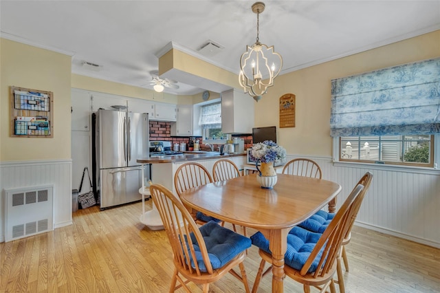 15 Peony Ln, Commack, NY 11725 - dining area featuring a wainscoted wall, light wood-type flooring, a ceiling fan, ornamental molding, and a chandelier