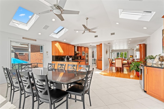 128 Seaman Rd, Jericho, NY 11753 - dining room with a skylight, a ceiling fan, vaulted ceiling, light tile patterned floors, and recessed lighting