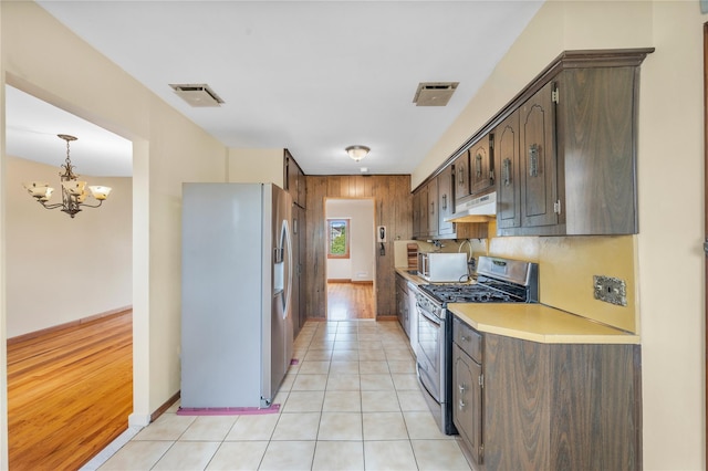 38 W 17th St, Deer Park, NY 11729 - kitchen with appliances with stainless steel finishes, under cabinet range hood, dark brown cabinets, light countertops, and a chandelier