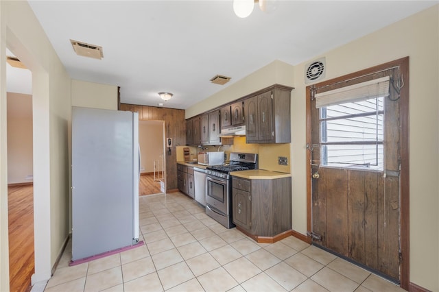 38 W 17th St, Deer Park, NY 11729 - kitchen with white appliances, light countertops, dark brown cabinets, under cabinet range hood, and light tile patterned floors