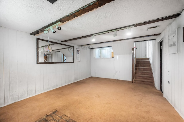 38 W 17th St, Deer Park, NY 11729 - below grade area with carpet floors, a textured ceiling, rail lighting, stairs, and wood walls