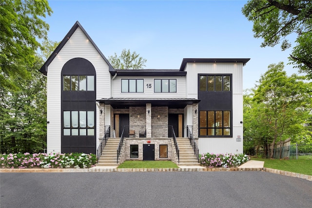 15 Gilda Ct, Spring Valley, NY 10977 - view of front facade with covered porch, stone siding, stairway, a standing seam roof, and a metal roof
