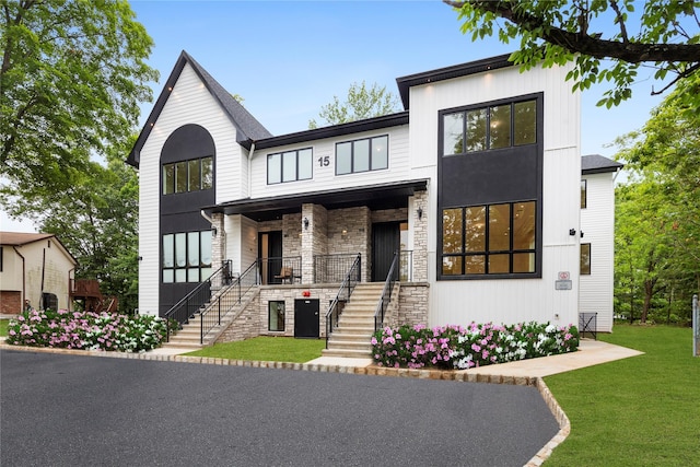 15 Gilda Ct, Spring Valley, NY 10977 - view of front of home featuring stairs, stone siding, a porch, and a front lawn
