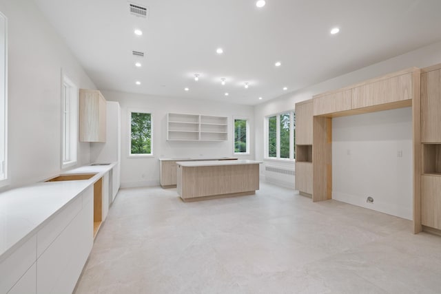 15 Gilda Ct, Spring Valley, NY 10977 - kitchen with light brown cabinetry, modern cabinets, a center island, recessed lighting, and open shelves