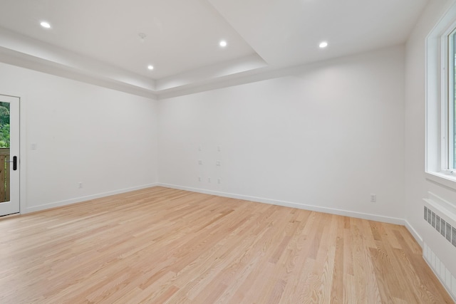 15 Gilda Ct, Spring Valley, NY 10977 - empty room with radiator heating unit, recessed lighting, light wood-style flooring, and a tray ceiling