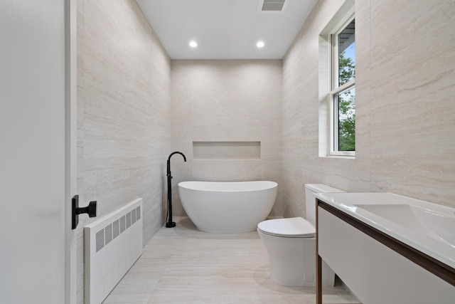 15 Gilda Ct, Spring Valley, NY 10977 - bathroom featuring radiator heating unit, tile walls, a freestanding tub, and vanity