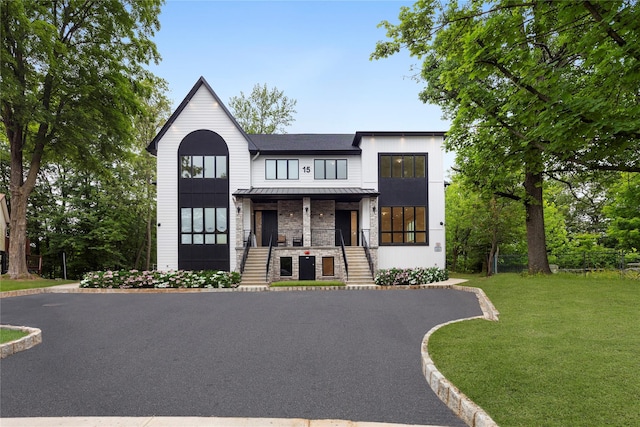 15 Gilda Ct, Spring Valley, NY 10977 - view of front of home with a standing seam roof, a front yard, a metal roof, a porch, and stone siding