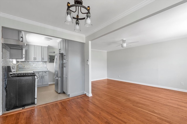 69-28 43rd Ave, Woodside, NY 11377 - kitchen featuring appliances with stainless steel finishes, gray cabinetry, a chandelier, light wood-style floors, and crown molding