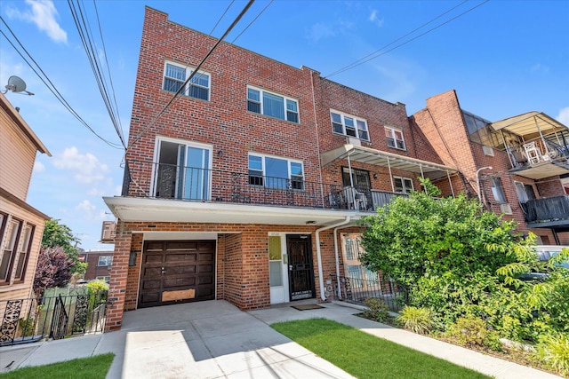 69-28 43rd Ave, Woodside, NY 11377 - view of property featuring brick siding, concrete driveway, and a garage