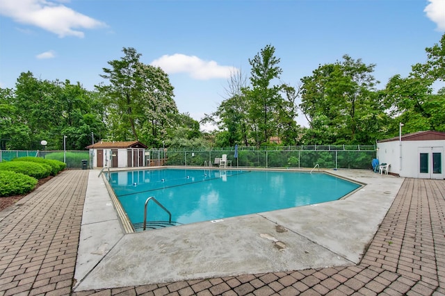 160 New Holland Vlg, Nanuet, NY 10954 - community pool with view of scattered trees, a patio area, and an outbuilding