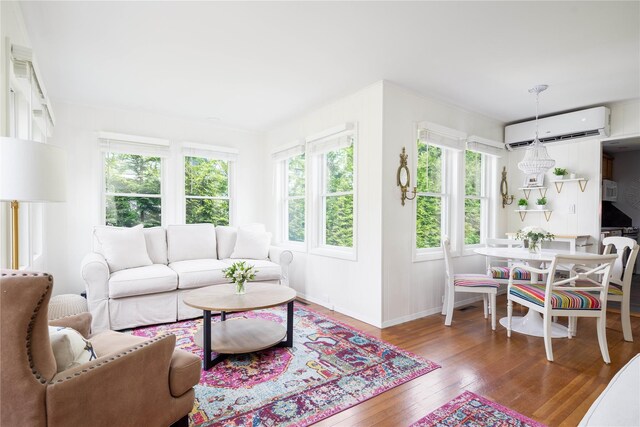 43 Washington Ave, Greenport, NY 11944 - living area featuring a wall mounted air conditioner, plenty of natural light, and wood-type flooring