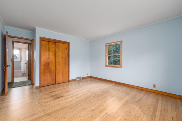 3000 Pequash Ave, Cutchogue, NY 11935 - unfurnished bedroom with multiple windows, a closet, light wood-type flooring, and ornamental molding