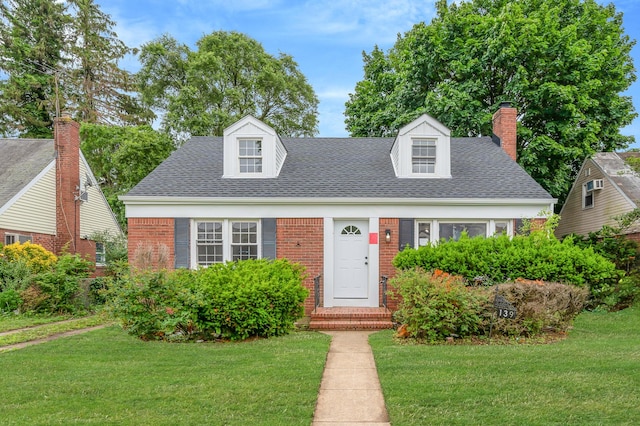 139 Jean Ave, Hempstead, NY 11550 - cape cod home featuring a front lawn, brick siding, roof with shingles, and a chimney
